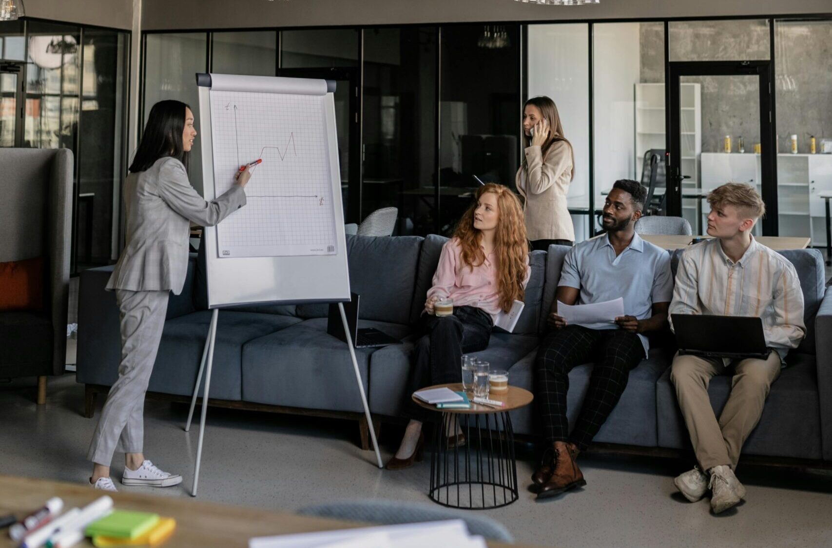 Our mission - Colleagues brainstorm during a business meeting in a stylish office space.